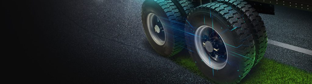 Two tires on a road with grass growing behind them and Halo Connect products installed