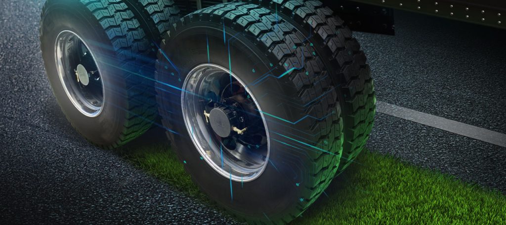 Two tires on a road with grass growing behind them and Halo Connect products installed